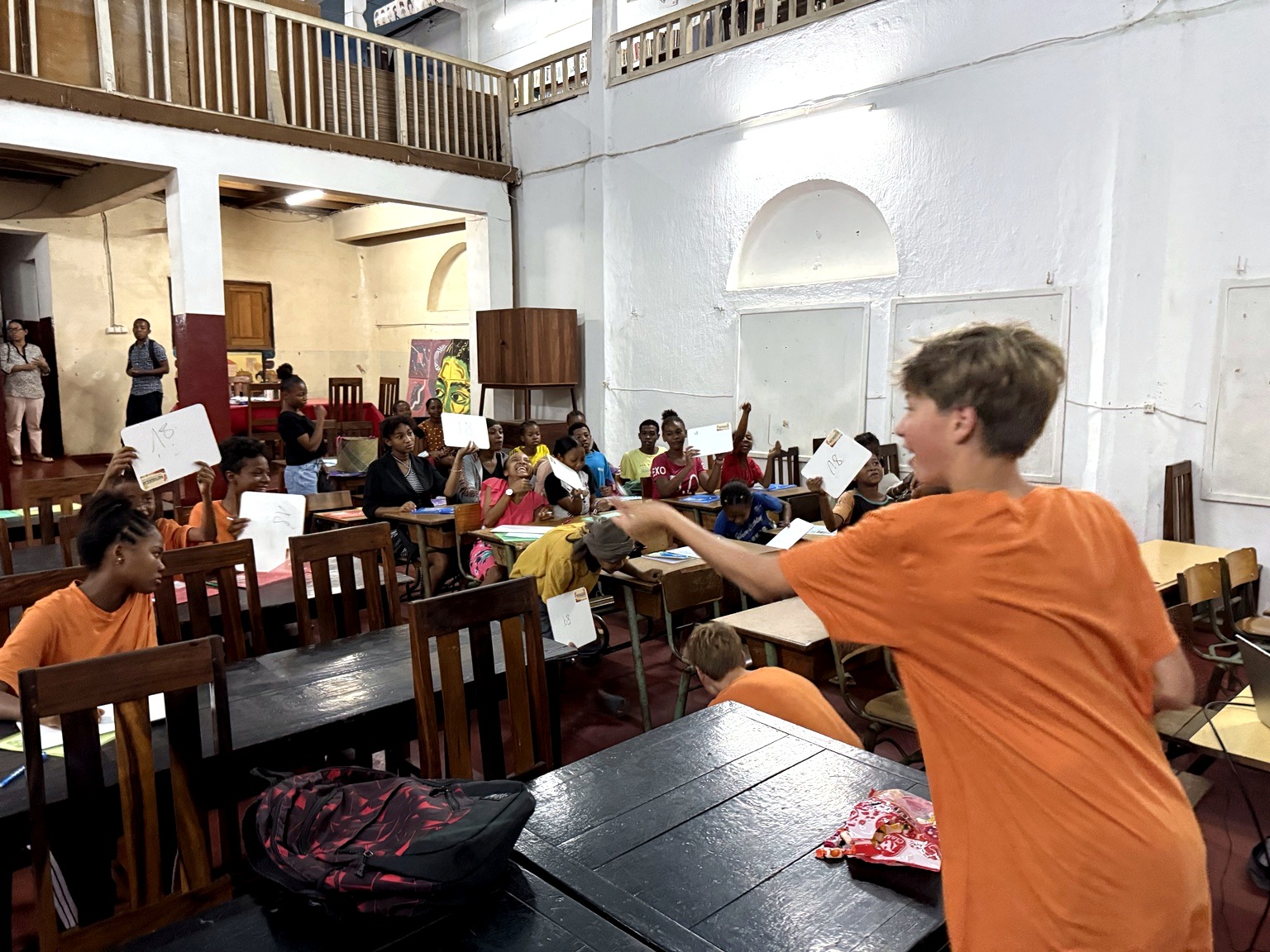 A Mathagascar volunteer leading a lively whiteboard quiz with students