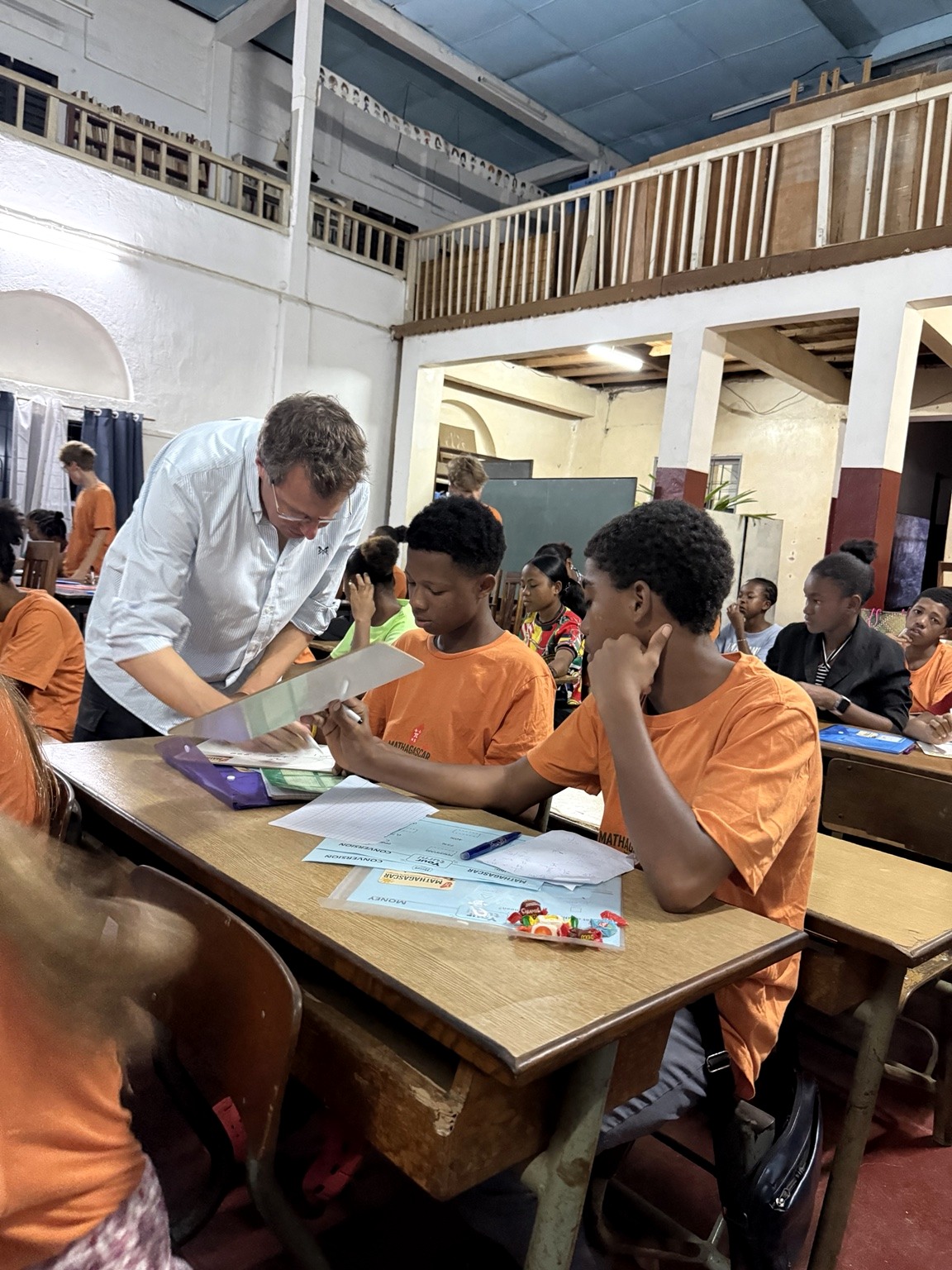 Volunteer helping Mathagascar students with a classroom exercise